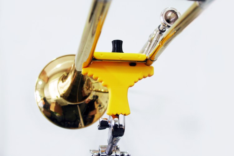 A bird shaped clip holding up a trombone