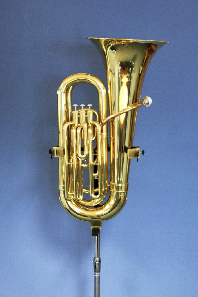 A tuba being held up on the stand.